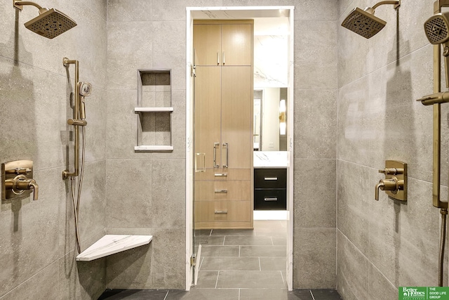 bathroom with vanity, tile walls, and tiled shower