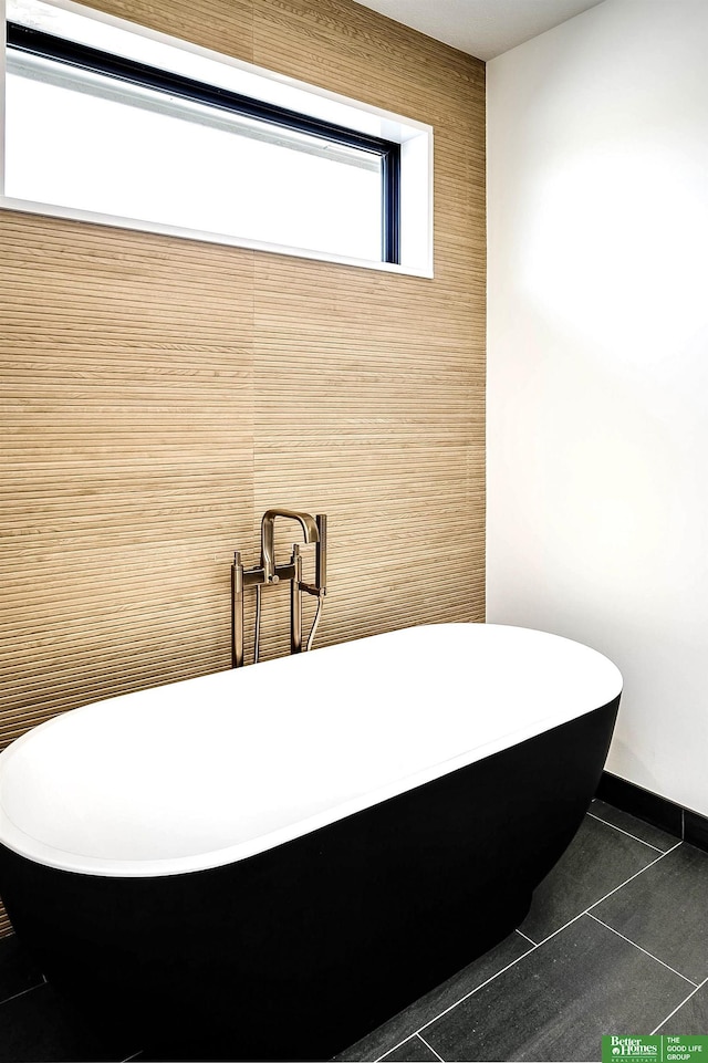 full bath with tile patterned flooring and a soaking tub