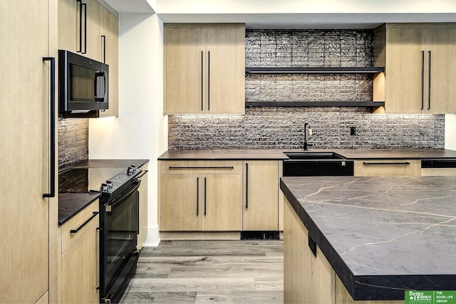 kitchen with black appliances, light wood-style flooring, light brown cabinets, a sink, and decorative backsplash