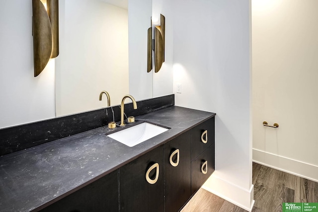 bathroom featuring vanity, wood finished floors, and baseboards