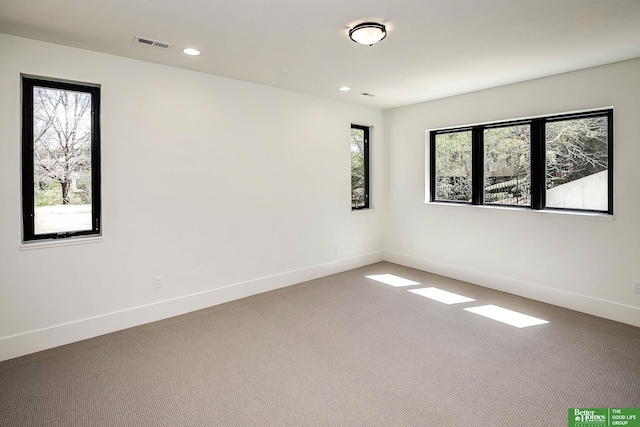 carpeted spare room with recessed lighting, baseboards, and visible vents