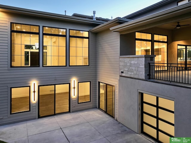 rear view of house with stucco siding and a patio