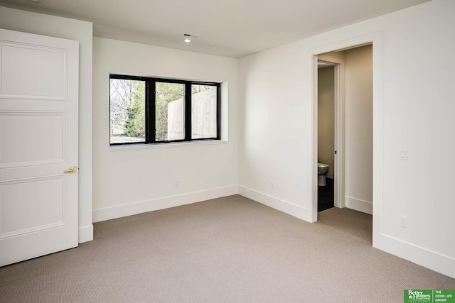 unfurnished bedroom featuring light carpet, visible vents, ensuite bathroom, and baseboards