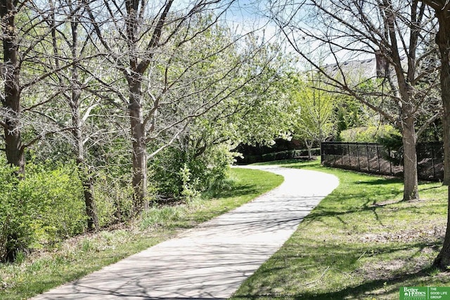 view of community with a lawn and fence