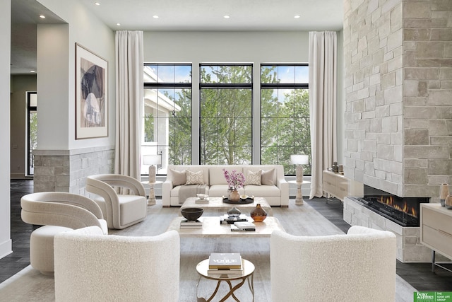 living area with a multi sided fireplace, recessed lighting, and wood finished floors