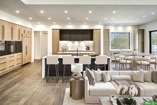 living room with light wood finished floors, heating unit, and recessed lighting