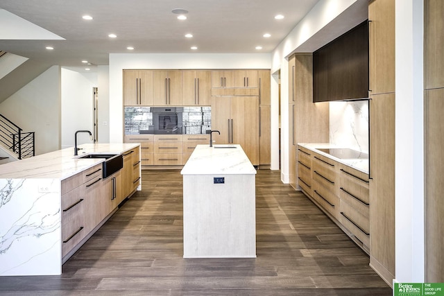 kitchen featuring a large island, modern cabinets, light brown cabinets, and a sink