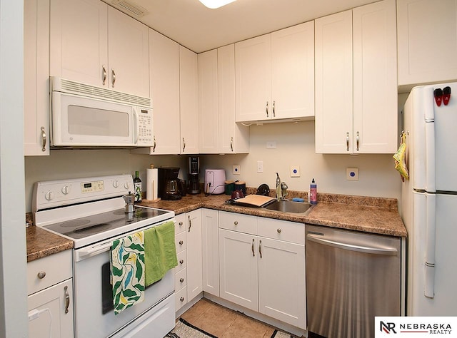 kitchen featuring a sink, visible vents, white appliances, and white cabinets