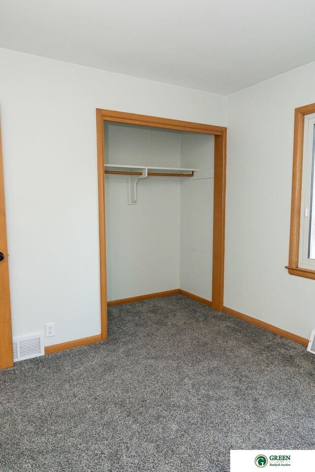 unfurnished bedroom featuring a closet, visible vents, baseboards, and carpet