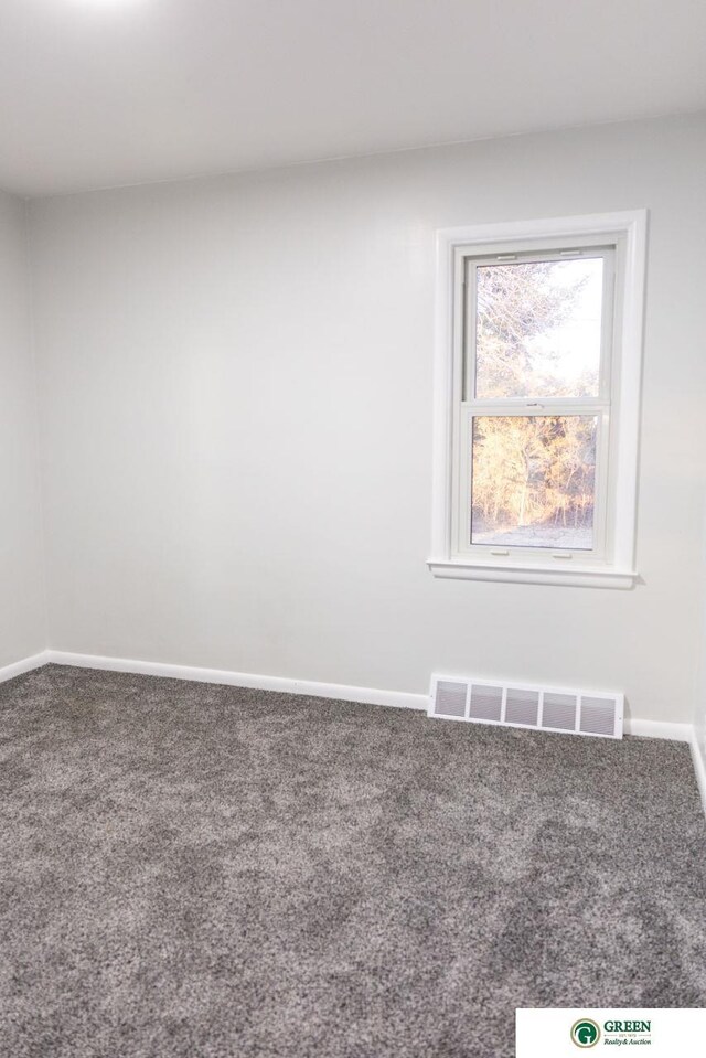 carpeted spare room with baseboards and visible vents