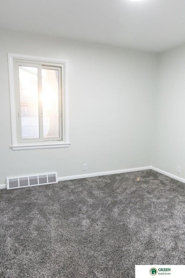 spare room with baseboards, visible vents, and carpet floors