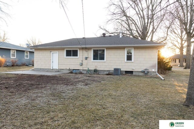 rear view of house featuring a patio area, a lawn, and a shingled roof