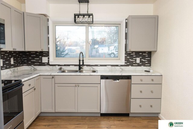 kitchen featuring a sink, gray cabinets, tasteful backsplash, and stainless steel appliances