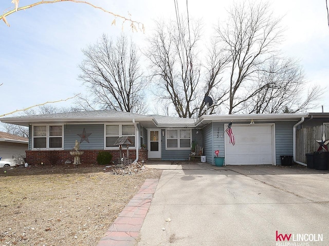 single story home with a garage, brick siding, and concrete driveway