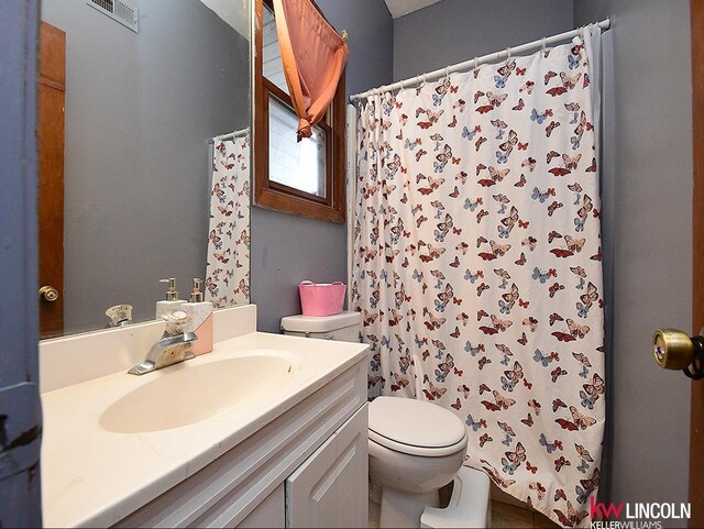 bathroom with visible vents, curtained shower, toilet, and vanity