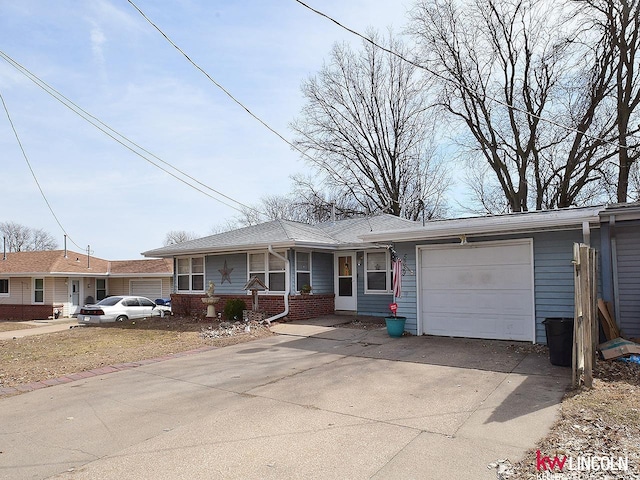 single story home with driveway, brick siding, and an attached garage