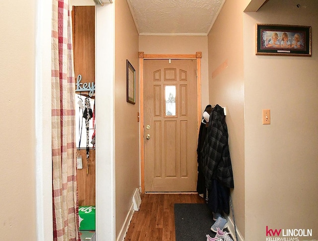 entryway with a textured ceiling, baseboards, and wood finished floors