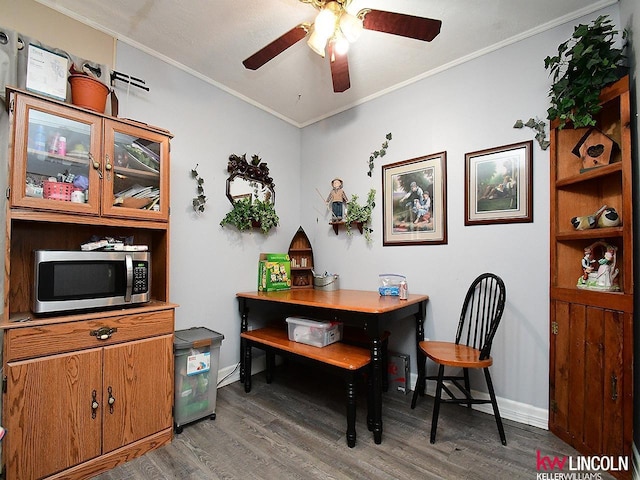 office space with crown molding, wood finished floors, baseboards, and ceiling fan