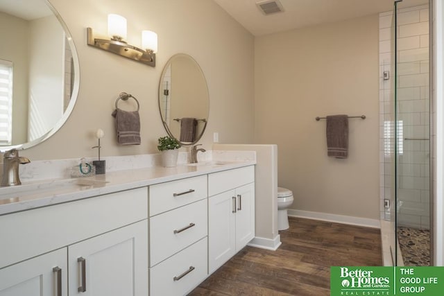 full bathroom featuring visible vents, baseboards, toilet, wood finished floors, and a sink