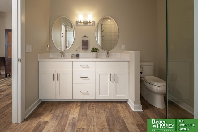 full bathroom featuring a sink, baseboards, toilet, and wood finished floors