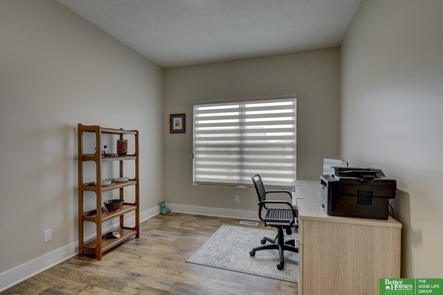 office area with baseboards and wood finished floors