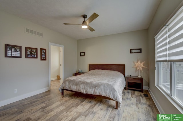 bedroom featuring visible vents, baseboards, wood finished floors, and a ceiling fan