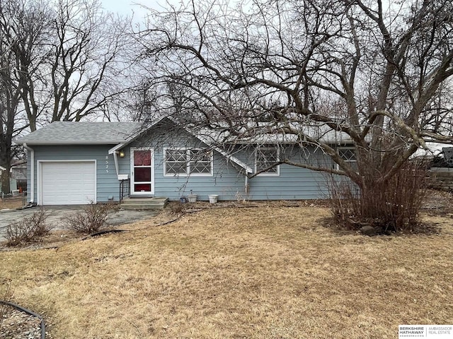 ranch-style house with aphalt driveway, an attached garage, a front yard, and entry steps