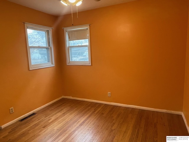 spare room with visible vents, light wood-type flooring, and baseboards