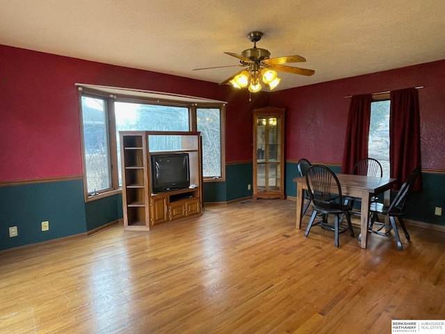 dining area featuring a healthy amount of sunlight, wood finished floors, and a ceiling fan