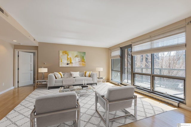 living room with visible vents, baseboards, and wood finished floors