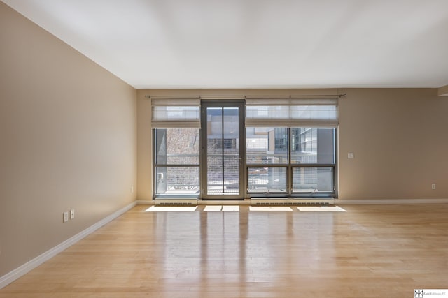 empty room with light wood-type flooring and baseboards