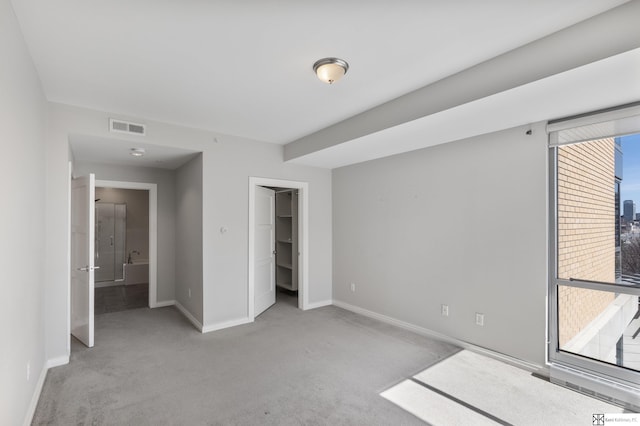 unfurnished bedroom with visible vents, light carpet, and baseboards