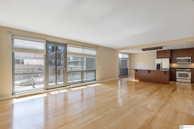 unfurnished living room with light wood-style floors and baseboards