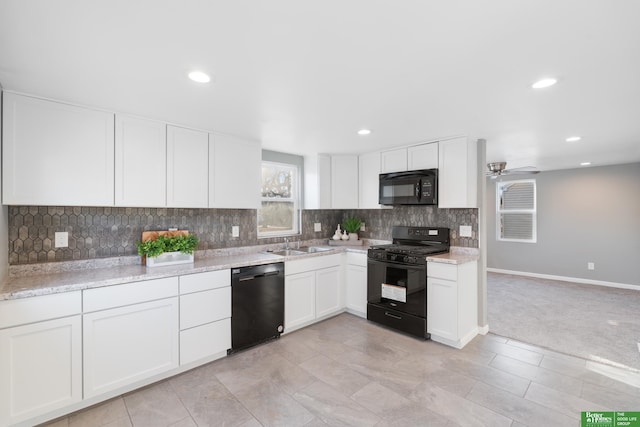 kitchen featuring backsplash, black appliances, ceiling fan, white cabinetry, and a sink