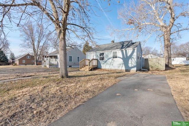 view of front of home with aphalt driveway, a residential view, and a chimney