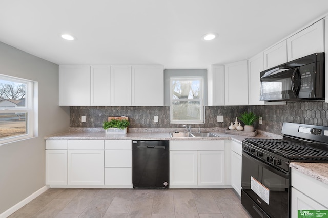 kitchen with backsplash, recessed lighting, white cabinets, black appliances, and a sink