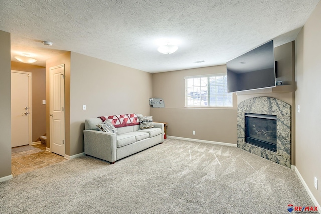 carpeted living room with stairway, a fireplace, a textured ceiling, and baseboards