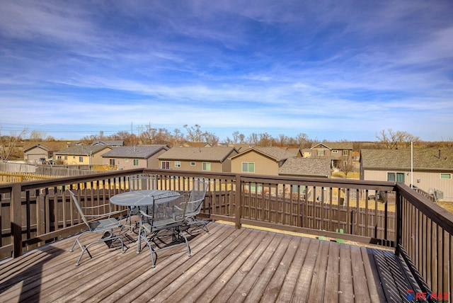 wooden terrace featuring a residential view and outdoor dining area