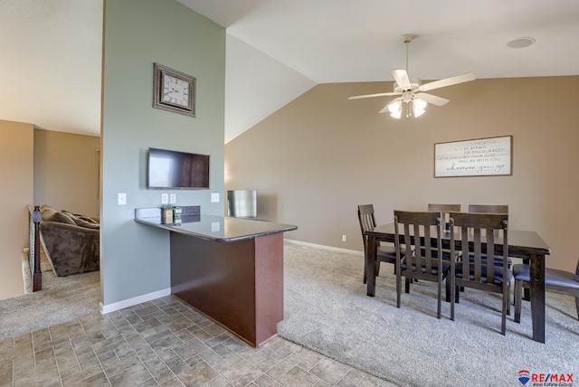 kitchen featuring baseboards, carpet floors, ceiling fan, and stone finish floor