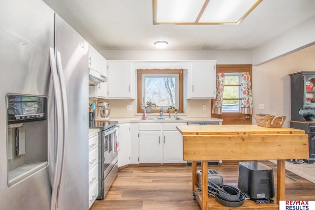 kitchen featuring a sink, under cabinet range hood, stainless steel appliances, white cabinets, and light countertops