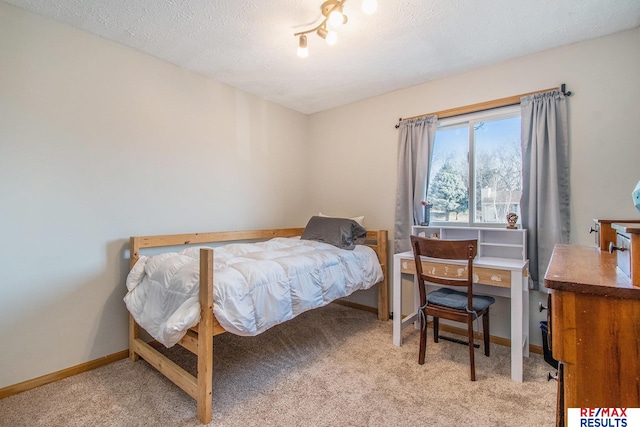 carpeted bedroom with baseboards and a textured ceiling