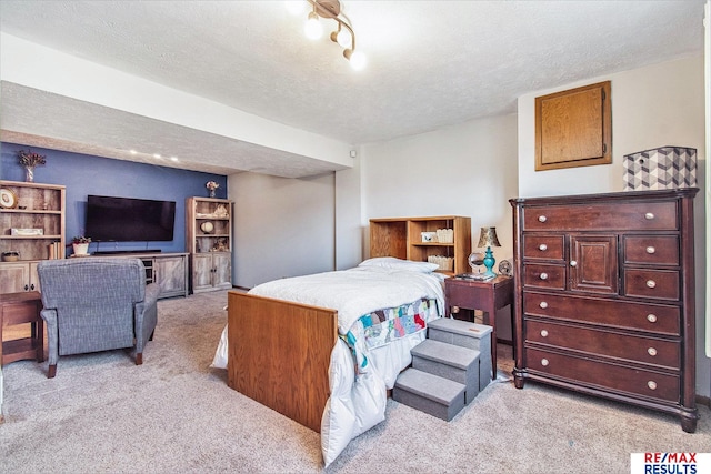 bedroom with light carpet and a textured ceiling