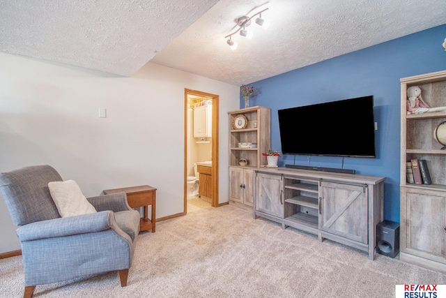 living area with light colored carpet, baseboards, and a textured ceiling