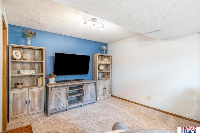 living area with carpet flooring, visible vents, baseboards, and a textured ceiling