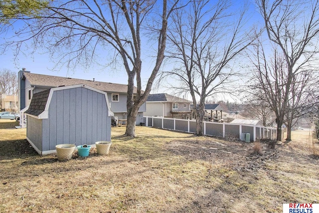 view of yard with a storage unit, a residential view, an outdoor structure, and fence