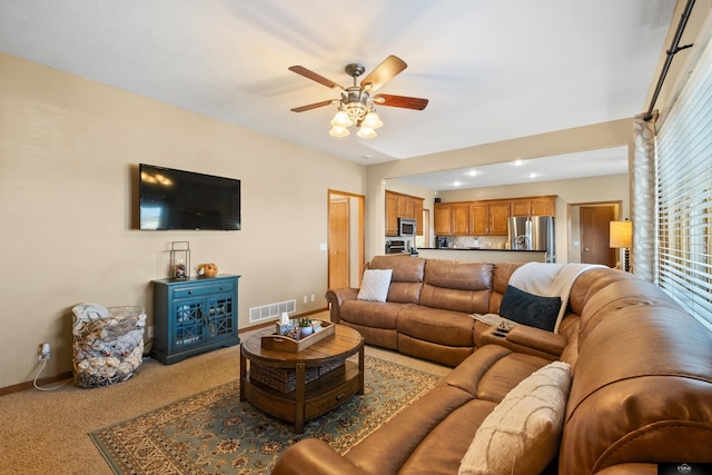 living area featuring a ceiling fan, baseboards, visible vents, and carpet floors