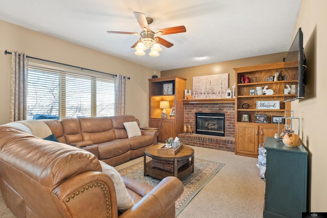 carpeted living room with a brick fireplace and ceiling fan