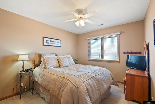 bedroom featuring ceiling fan, baseboards, visible vents, and light carpet