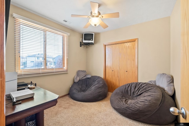 living area with visible vents, baseboards, a ceiling fan, and carpet flooring