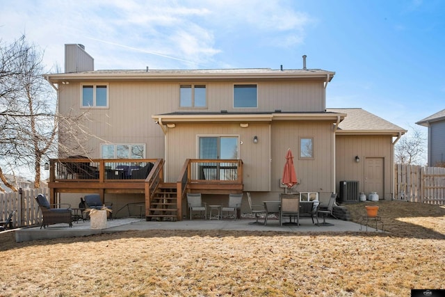 back of property featuring fence, a wooden deck, central AC, a chimney, and a patio